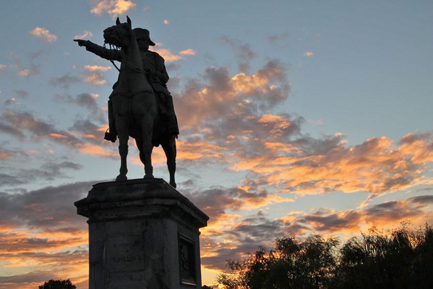 Statue équestre de Napoléon devant un coucher de soleil